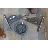 Two cast iron handing brackets and a metal lion door knocker