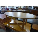 An oval teak single drawer coffee table