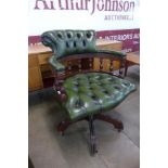 A mahogany and green leather revolving Captain's desk chair