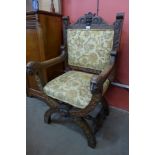 A 17th Century style carved oak and fabric upholstered green man x-frame chair