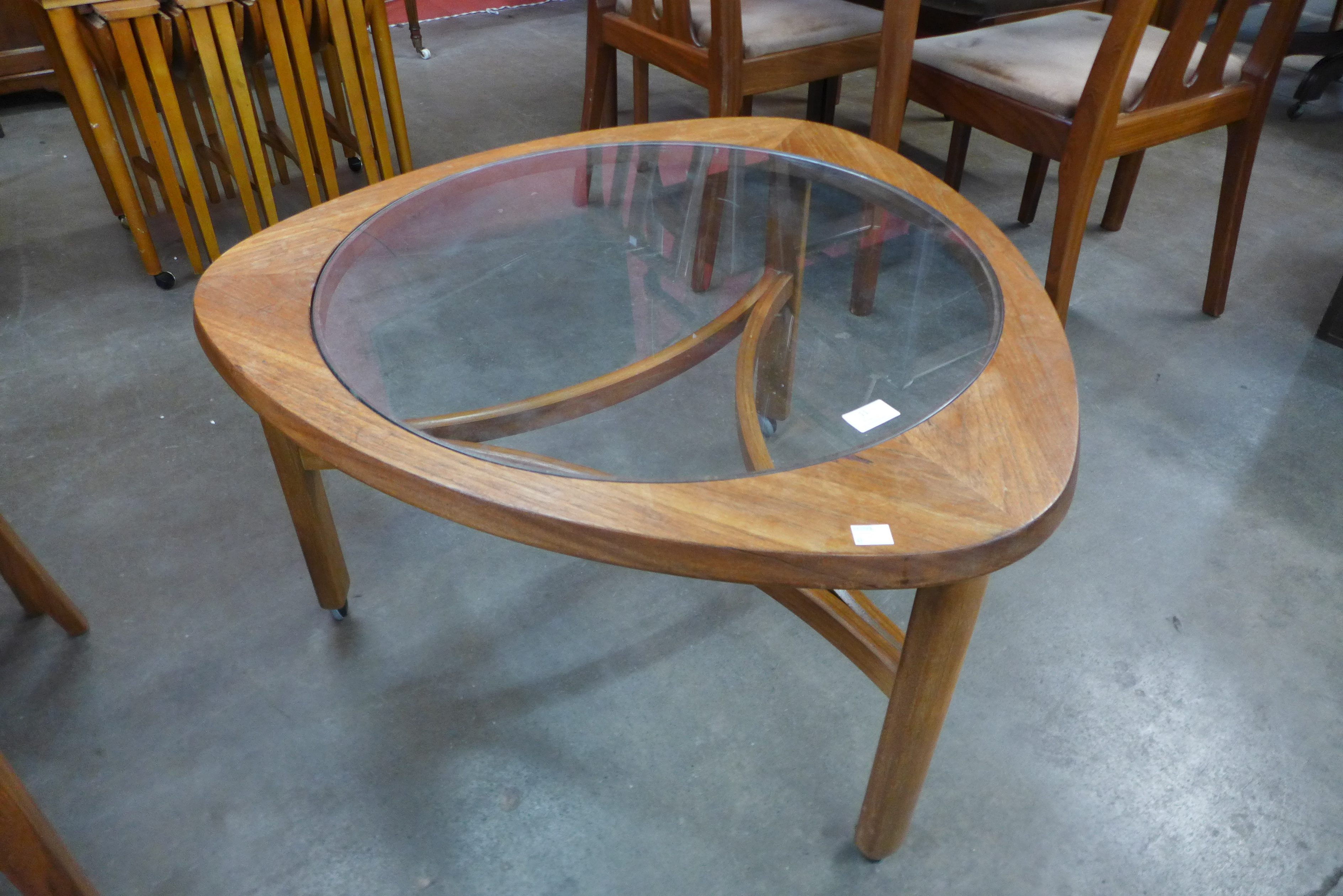 A Nathan teak and glass topped triangular coffee table