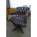 A mahogany and brown leather revolving Captain's desk chair