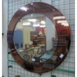 An Art Deco style peach glass circular mirror