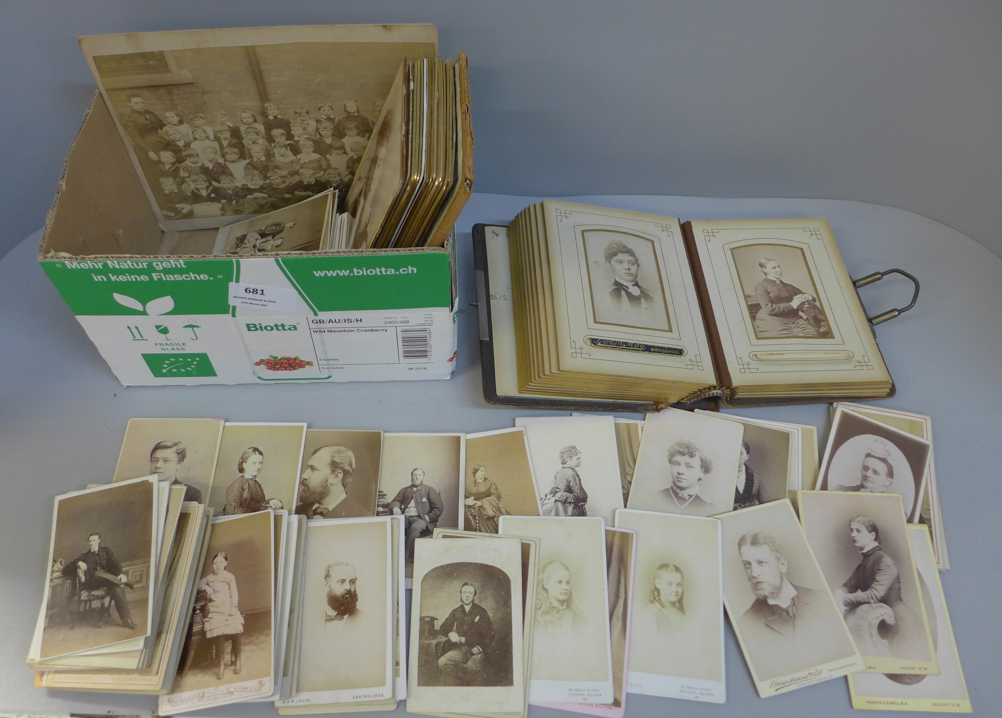 A carte de visite album with a collection of loose cabinet cards and carte de visite