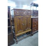 An early 20th Century oak geometric moulded cupboard on barleytwist stand