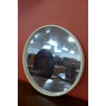 A circular white laminate framed mirror