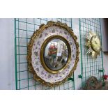 A gilt metal and Staffordshire pottery framed convex mirror