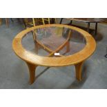 A circular teak and glass topped coffee table