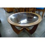 A circular teak and glass topped coffee table