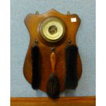 An oak wall hanging aneroid barometer/brush set