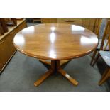 A circular rosewood effect extending dining table