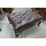 A chestnut brown leather Chesterfield footstool