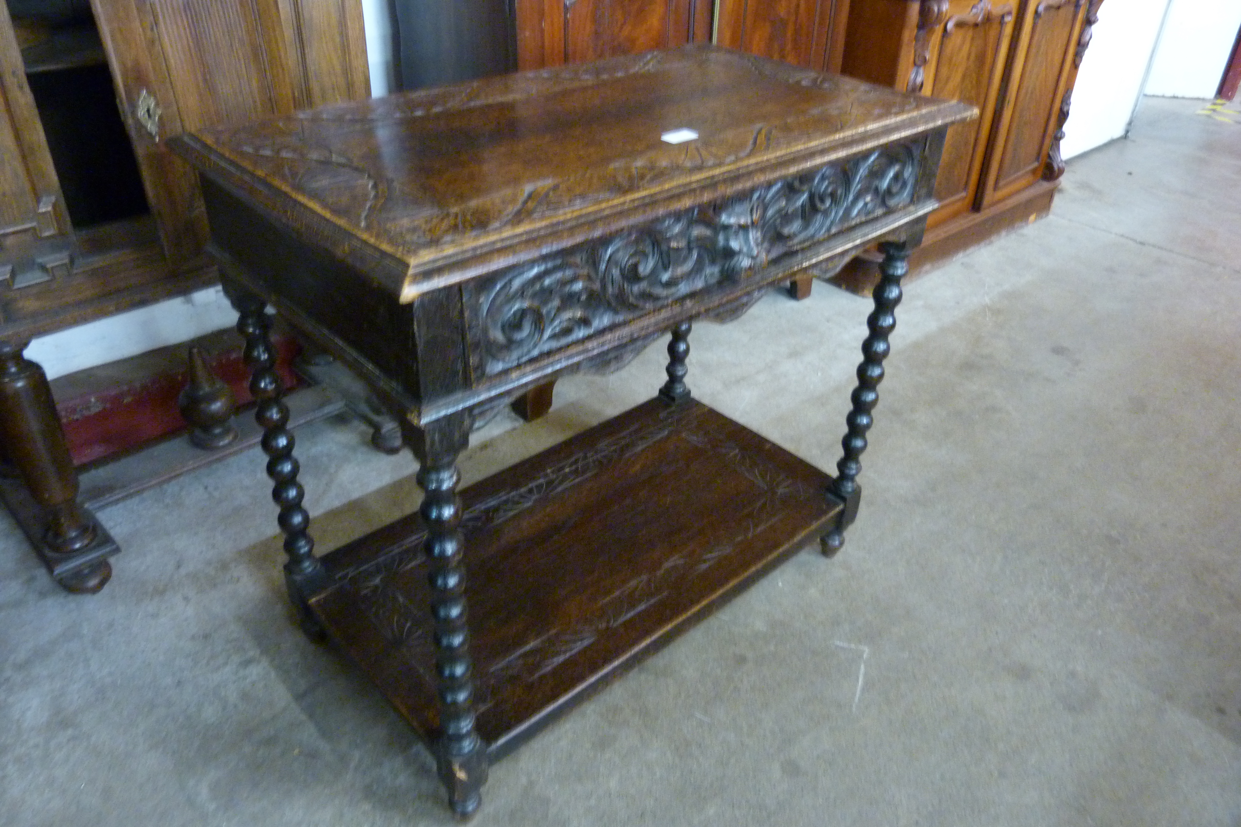 A 17th Century style carved oak single drawer Greenman side table