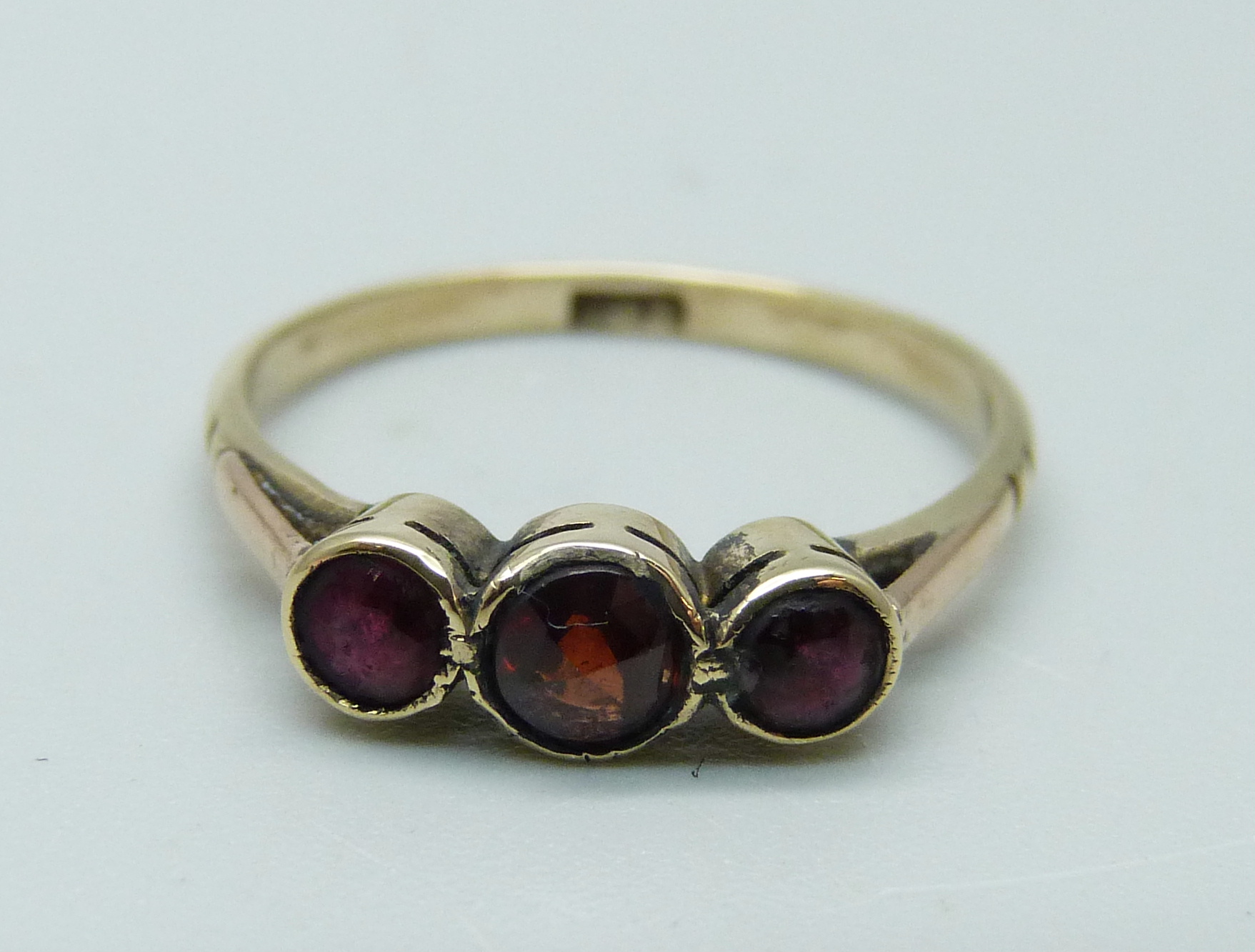 A 9ct gold and garnet trilogy ring, N
