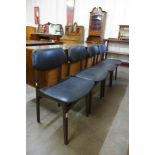 A set of four teak and black vinyl dining chairs