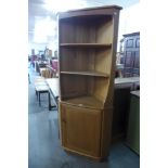 An Ercol blonde corner cupboard