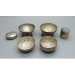 Two silver boxes, one with screw top, two white metal salts with Nile scene decoration and a white