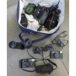 A bag of vintage cameras and binoculars, including Nikon and Olympus