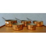 A set of five graduated copper coated saucepans