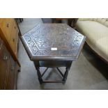 An Arts and Crafts carved oak hexagonal occasional table