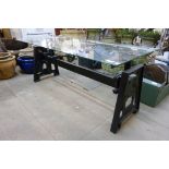 An industrial style steel and glass topped coffee table
