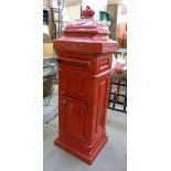 A red painted cast iron post box, with key