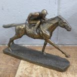 A bronzed resin figure of a racehorse and jockey