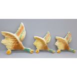 A set of three flying ducks wall plaques