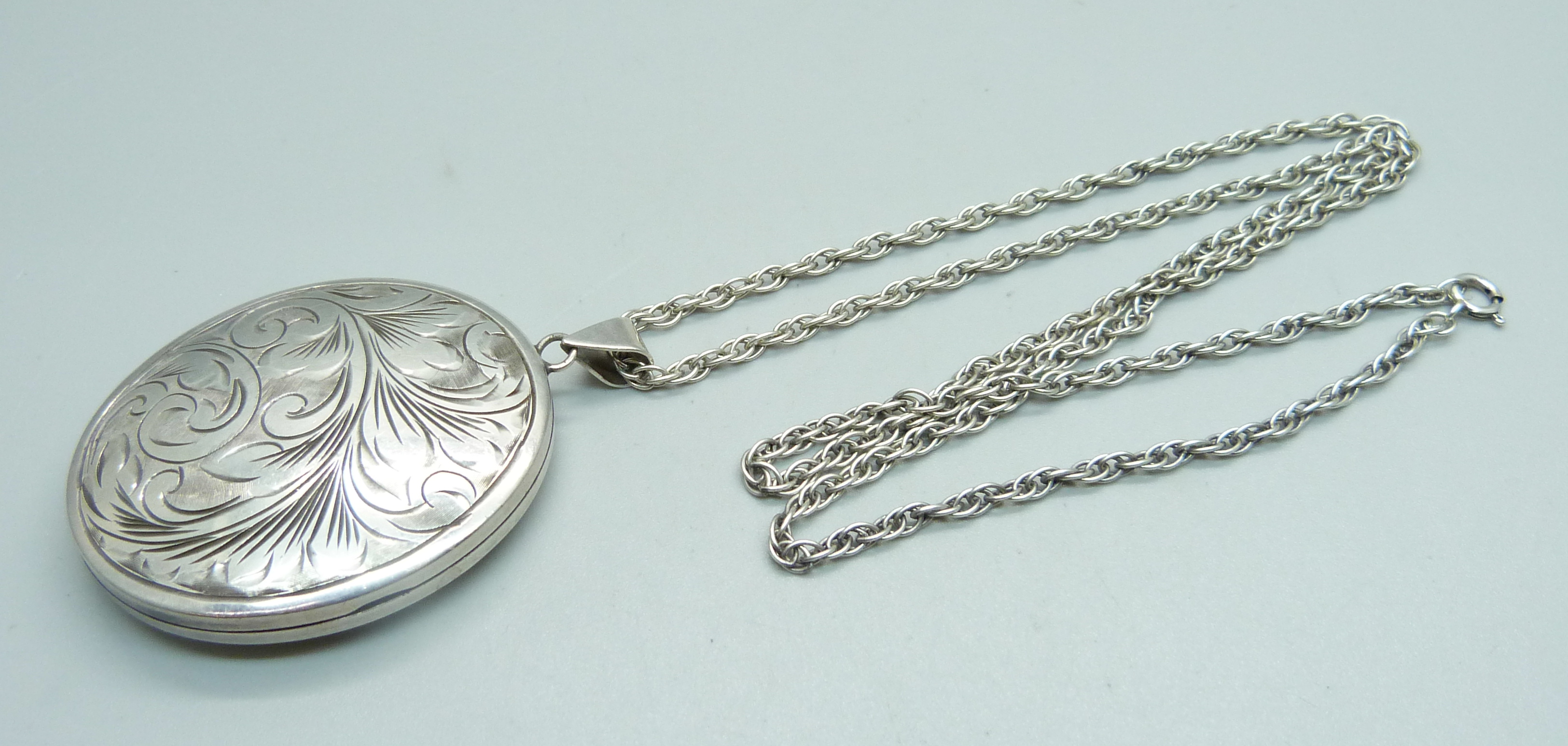 A large silver engraved locket on chain