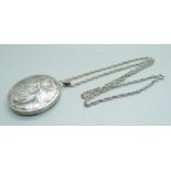 A large silver engraved locket on chain
