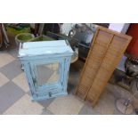 A small painted mirrored wall cabinet and a clocking in card holder