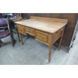 A Victorian pitch pine three drawer writing table