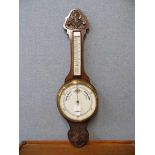 An early 20th Century carved oak aneroid barometer