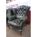 A green leather Chesterfield wingback armchair