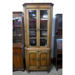 An early 20th Century oak freestanding splay front corner cabinet