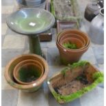 Six terracotta plant pots and a small green glazed terracotta bird bath