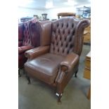 A brown leather Chesterfield wingback armchair