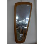 An asymmetric teak framed mirror