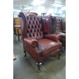An oxblood red leather Chesterfield wingback armchair