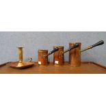 A set of three graduated copper measuring jugs and a chamberstick