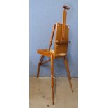 A teak artist's fitted travelling easel, with paints
