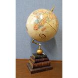 A desk top terrestrial globe, on faux book stand