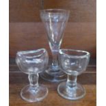 An 18th Century wine glass and two eye baths