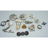 A collection of badges and brooches including silver