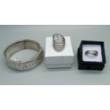 A silver bangle and two silver rings, (bangle dented)