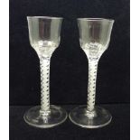 A pair of 18th Century wine glasses, each with moulded ogee bowl over a double series open twist