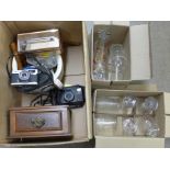 A box of assorted items including two cameras, perpetual calendar, brass button cleaner and