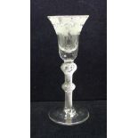 An 18th Century wine glass having a bell bowl with solid base and with an engraved frieze of vines