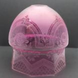 An etched cranberry glass shade with octagonal base