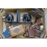 A box containing two pairs of book ends, onyx and ebony elephants, lighters, paperweights, two hip